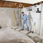 man in basement removing cement floor